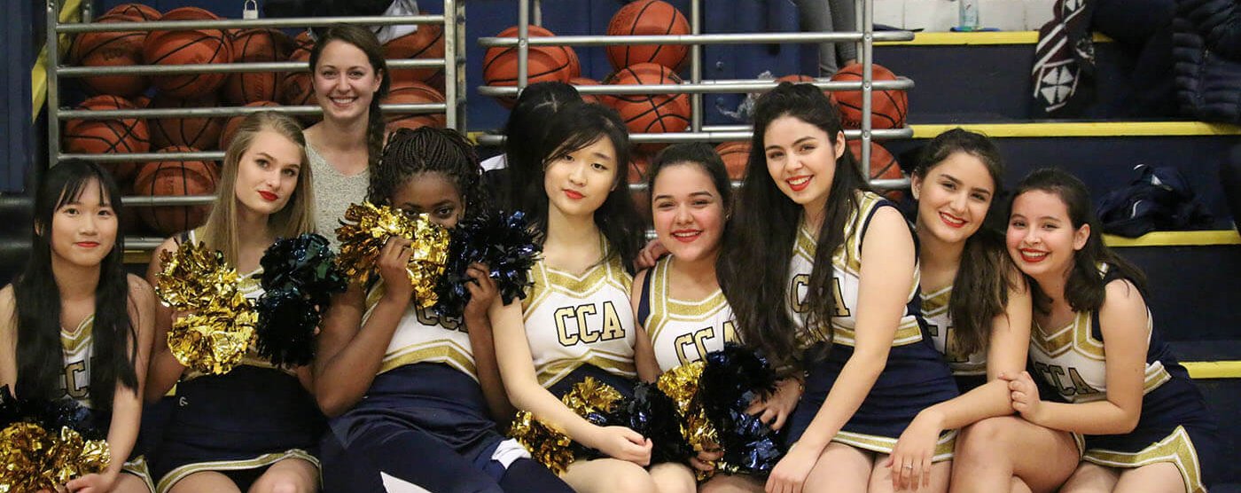 christian academy, cheerleaders, sit together, smiling