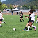 American boarding school, fall sports, include girls' soccer, player runs next to opposing player, to take soccer ball