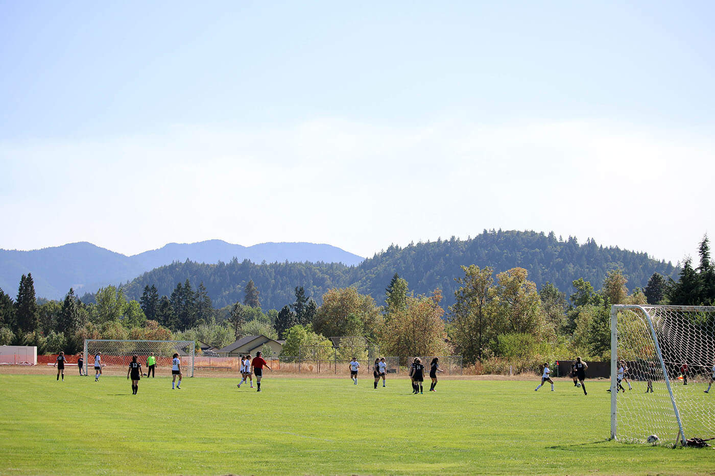 Christian boarding school, girls' soccer team, plays a home game, at south umpqua's field, with a beautiful backdrop, of the Cascade mountains